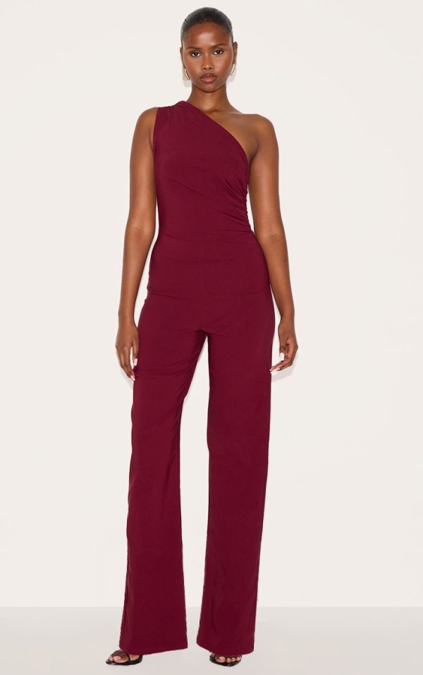 72461612b32e8b294c377f5f436f7cbbe790a9b3_CNM3112_1_wine_stretch_woven_one_shoulder_ruched_flared_jumpsuit