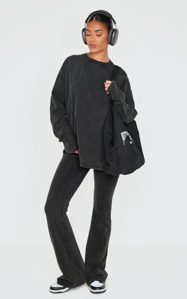 7758c7b7d34f794668fc9caae04925a98dacfaab_CNK5263_1_prettylittlething_black_embossed_logo_washed_skinny_flare_trousers