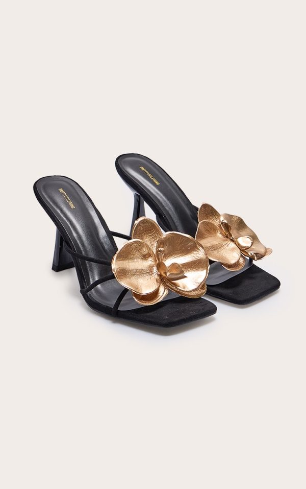 dd1a38007451f96902748691cd5a279078ceeacd_CNK3612_2_black_faux_suede_square_toe_gold_flower_detailed_heeled_mules
